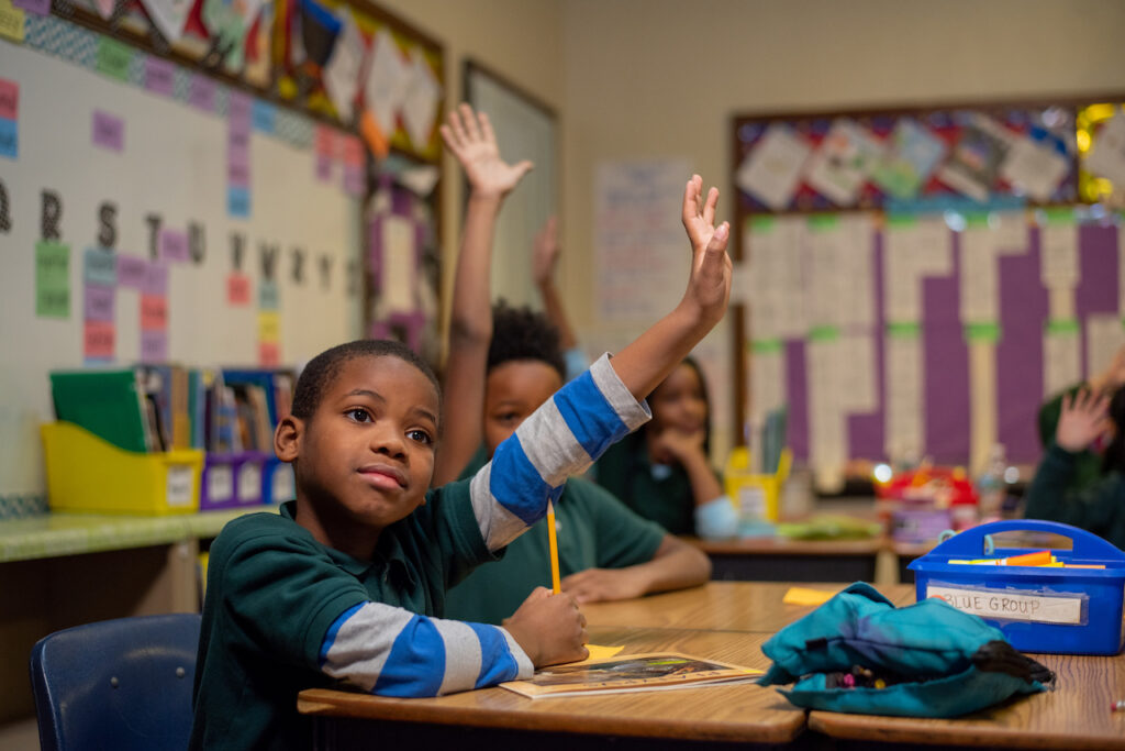 Classroom Picture of a Young Student Raising Hand